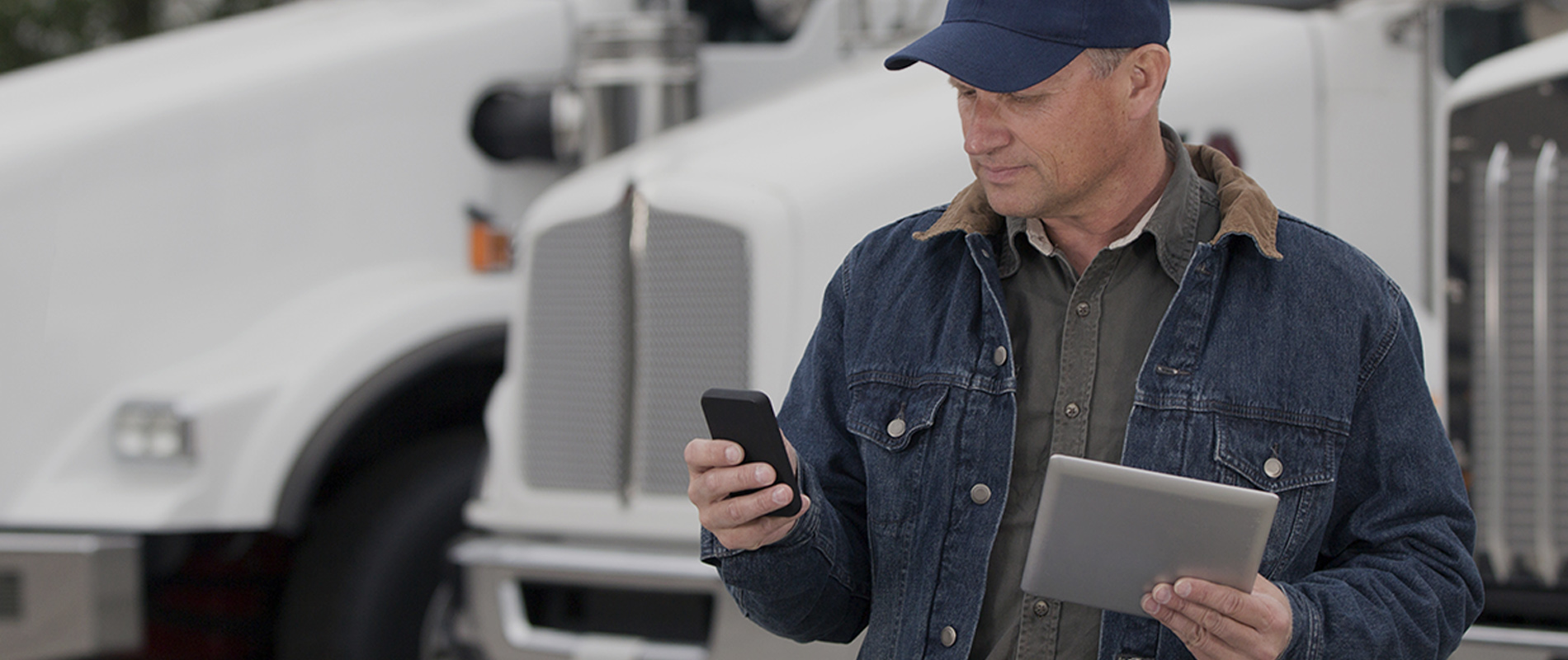 Vrachtwagen chauffeur werkt met mobiel